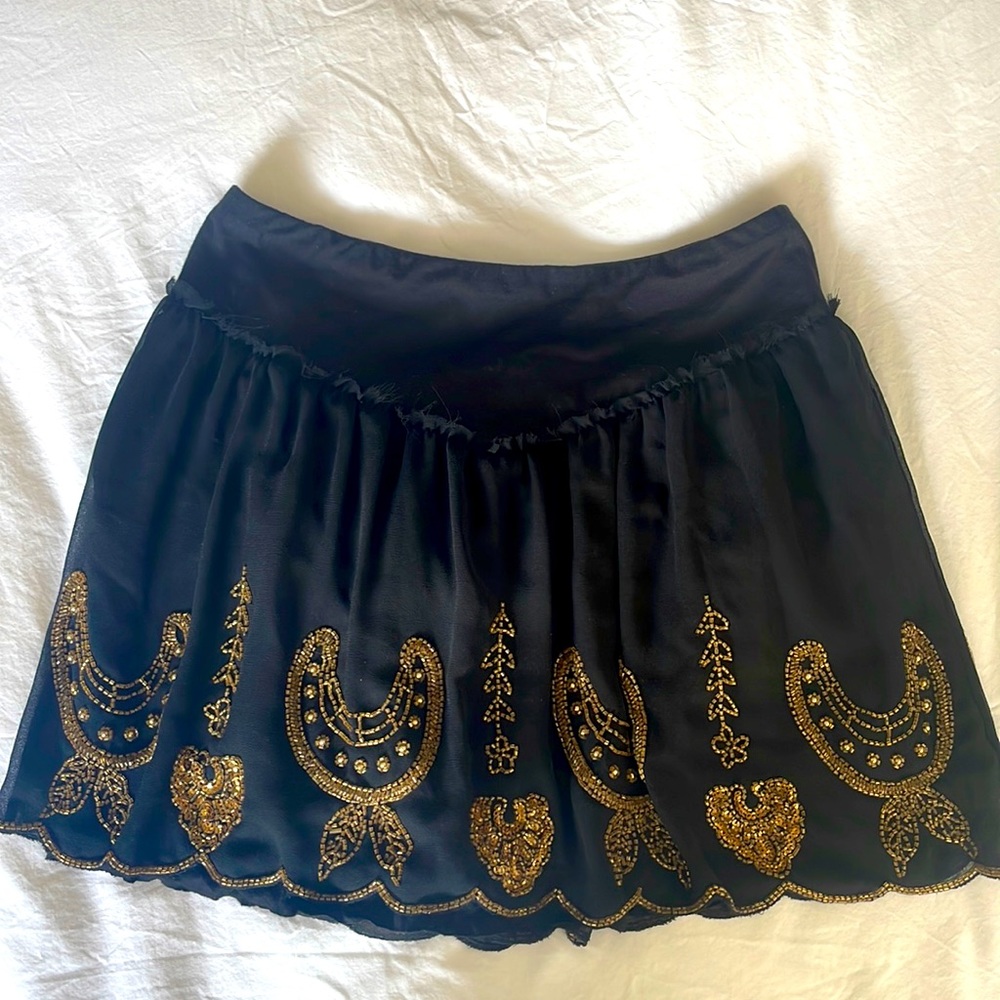 Black chiffon shirt skirt, elasticated wide waistband. Gold sequin detail.